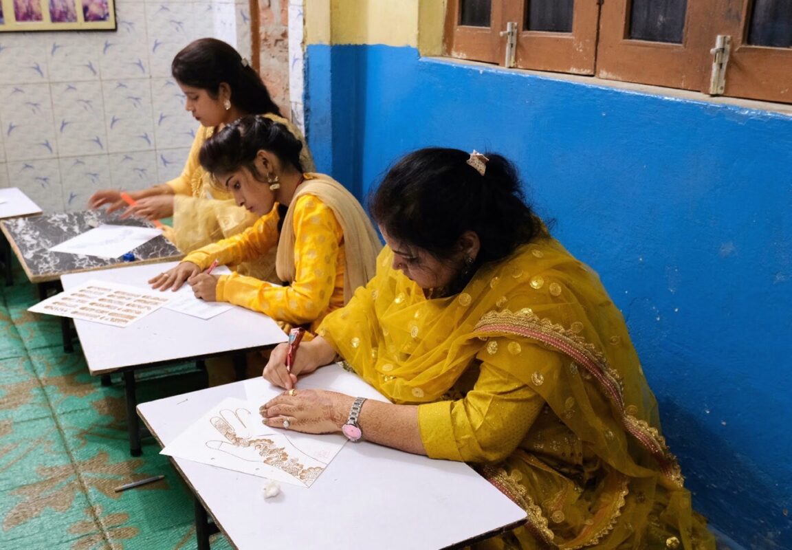 Deze dames leren hoe ze bruidsmake-up en Mehndi (henna) moeten aanbrengen.